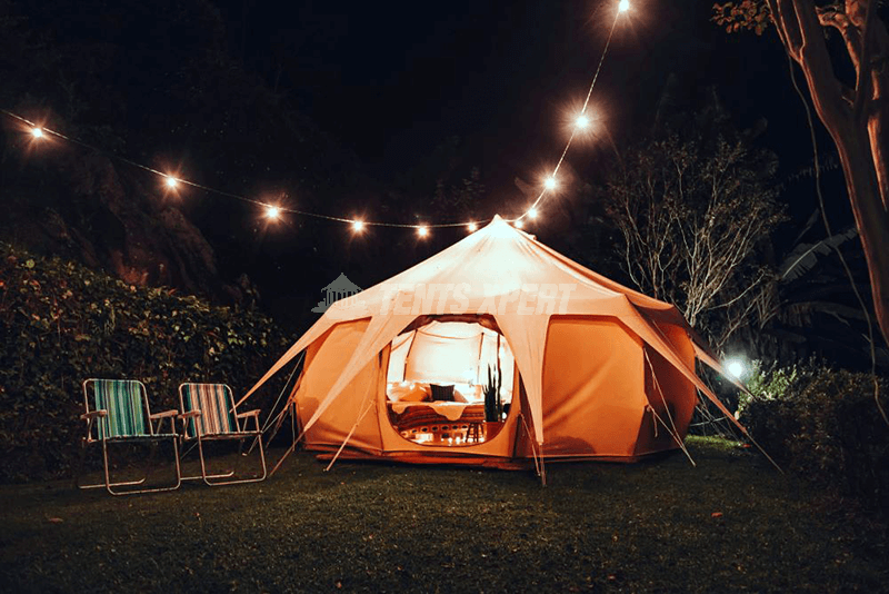 A beautiful tent with two chairs under lights