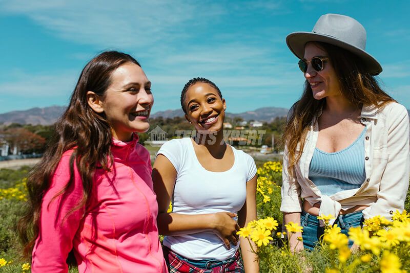 Three girls laughing while being in the outdoors